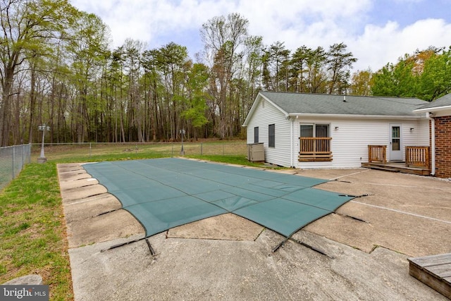view of swimming pool with a patio, a fenced backyard, a deck, and a covered pool