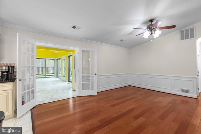 spare room with french doors, light wood finished floors, and visible vents