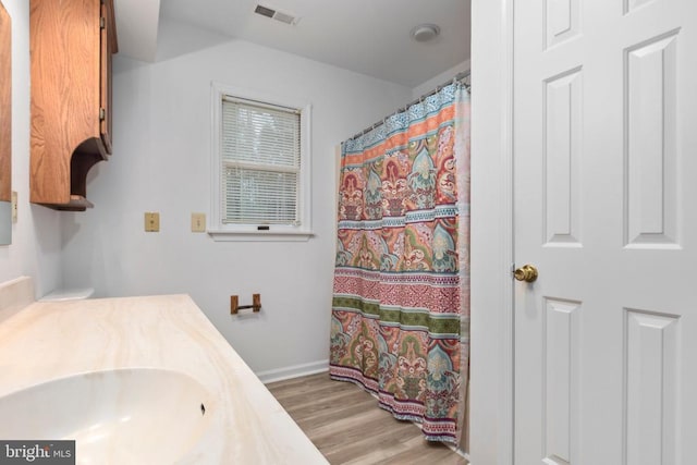 bathroom featuring visible vents, baseboards, a shower with curtain, vanity, and wood finished floors