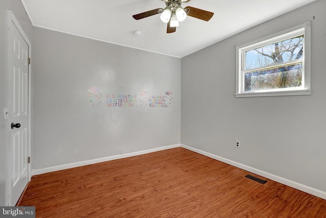 spare room with visible vents, ceiling fan, baseboards, and wood finished floors