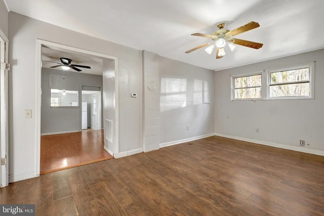 spare room featuring visible vents, wood finished floors, baseboards, and ceiling fan