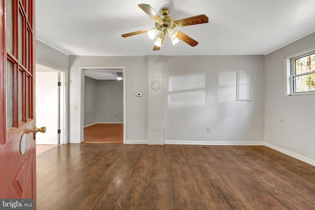 empty room with baseboards, ceiling fan, and wood finished floors