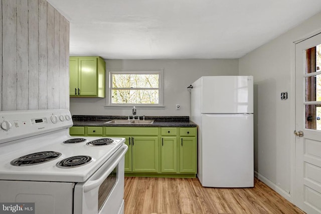 kitchen with light wood finished floors, white appliances, green cabinets, and a sink