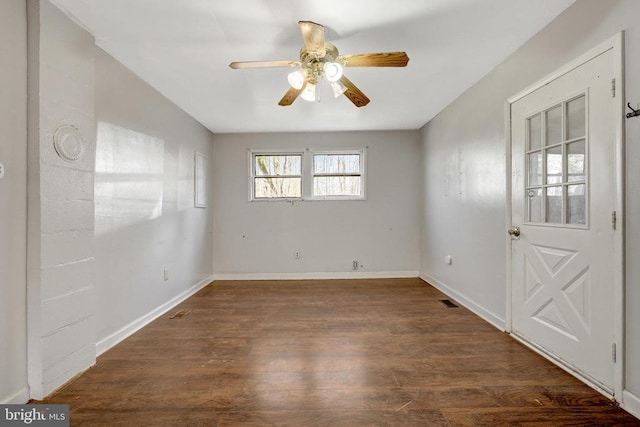 unfurnished room with a ceiling fan, visible vents, wood finished floors, and baseboards