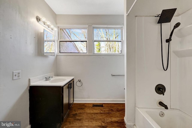 full bath with plenty of natural light, vanity, shower / tub combination, and wood finished floors