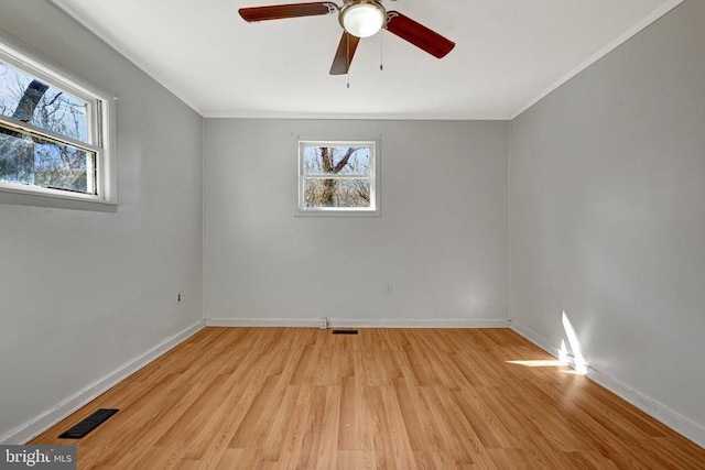 spare room featuring light wood-style flooring, baseboards, visible vents, and ceiling fan