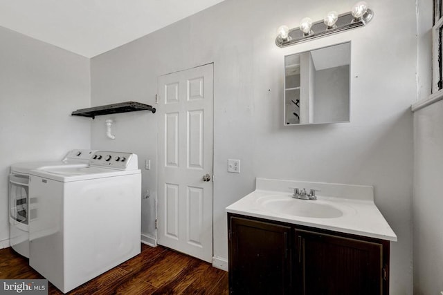 washroom featuring a sink, dark wood finished floors, and washer and clothes dryer