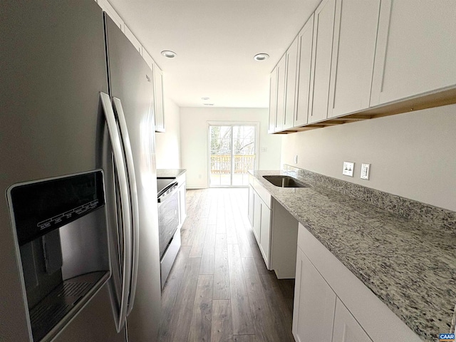 kitchen featuring white cabinets, stainless steel fridge with ice dispenser, and a sink