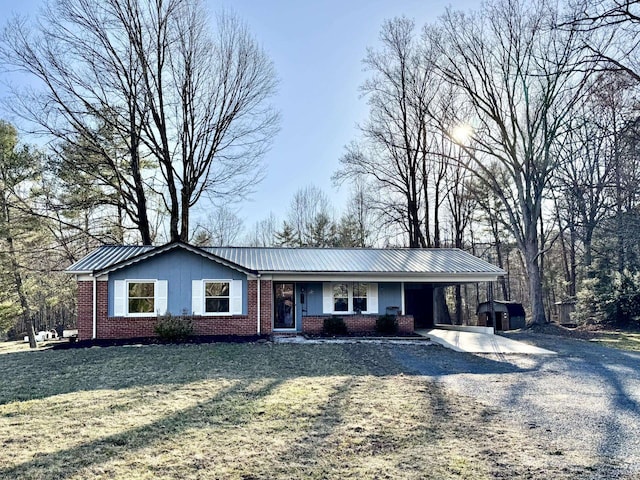 ranch-style house with a carport, a front lawn, brick siding, and driveway