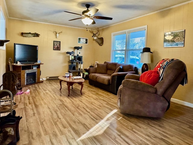 living room with a ceiling fan, wood finished floors, a fireplace, crown molding, and baseboards