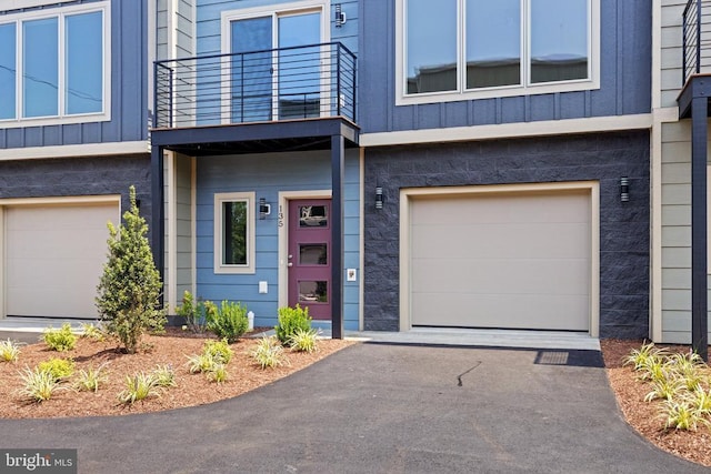 view of front facade featuring a garage and a balcony