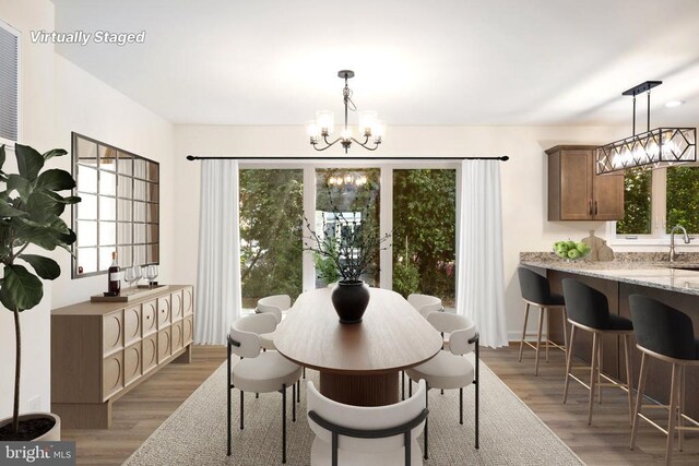 dining area featuring dark wood-type flooring, a healthy amount of sunlight, and a notable chandelier