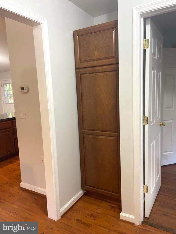 corridor with dark hardwood / wood-style flooring