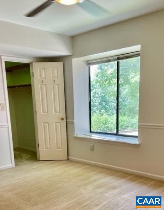 carpeted empty room featuring ceiling fan