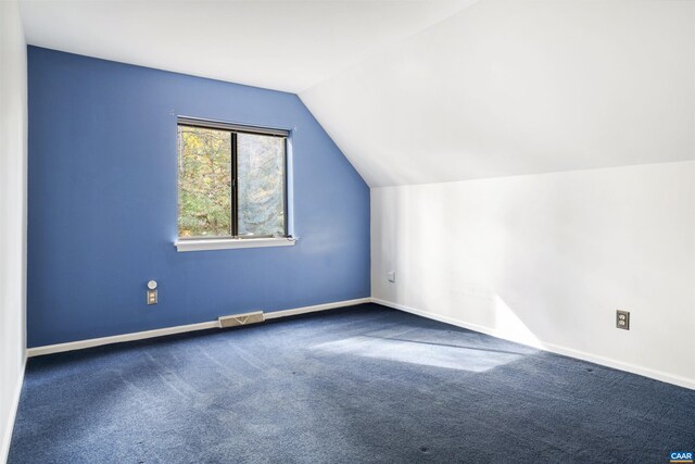 additional living space featuring lofted ceiling and carpet flooring