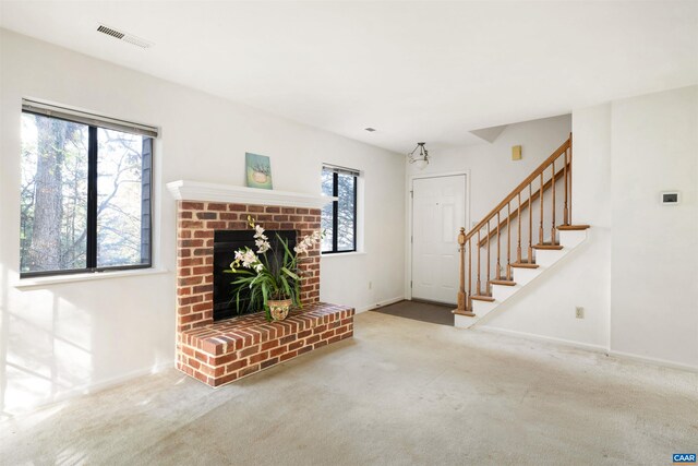 unfurnished living room with a brick fireplace and carpet floors