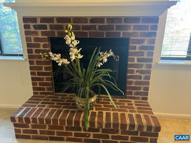 interior details with carpet flooring and a brick fireplace