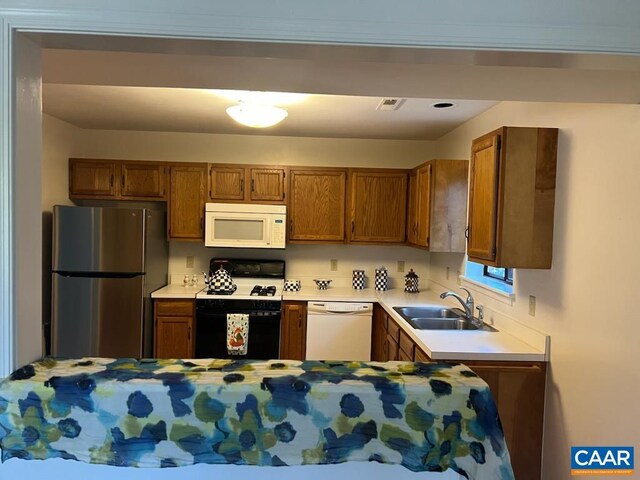 kitchen featuring white appliances and sink