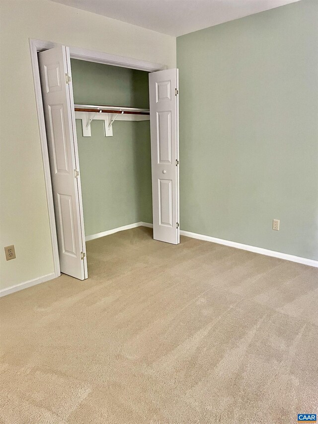 unfurnished bedroom featuring carpet flooring and a closet