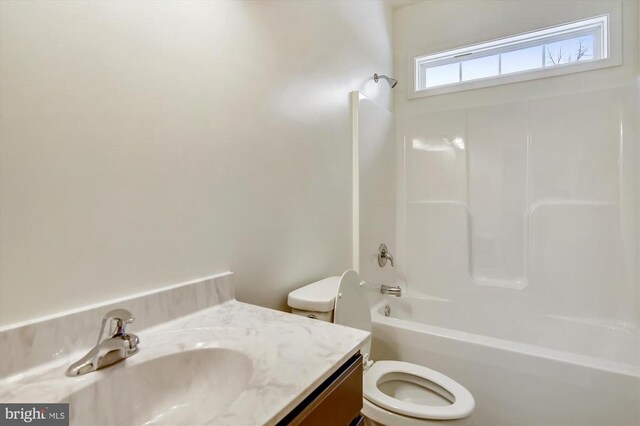 full bathroom featuring vanity, bathtub / shower combination, and toilet