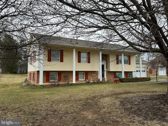 raised ranch with brick siding and a front yard