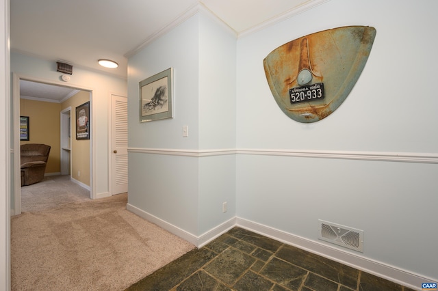 hallway featuring ornamental molding and dark carpet