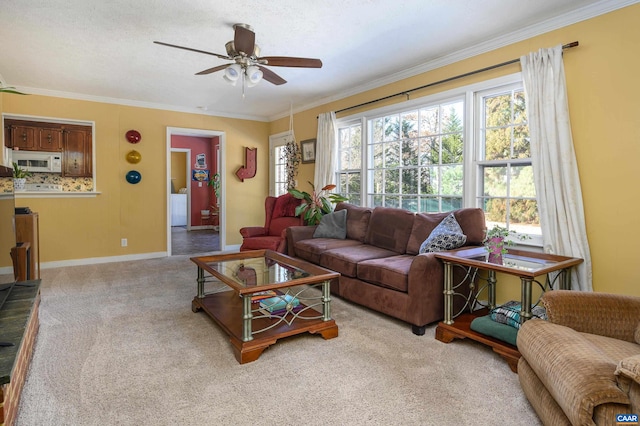 living room featuring ceiling fan, light colored carpet, ornamental molding, and a textured ceiling