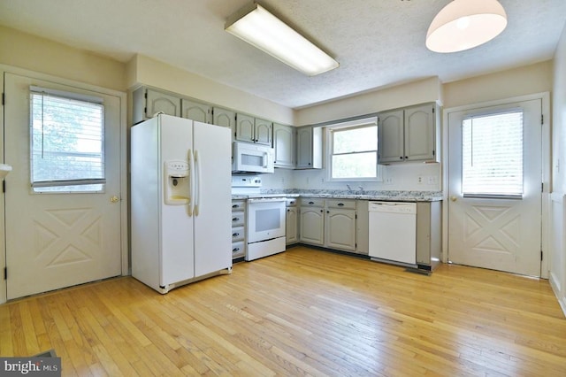 kitchen with white appliances, gray cabinets, and light wood finished floors