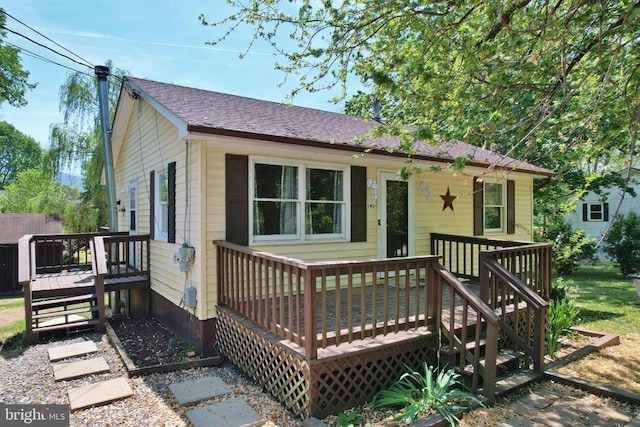 view of front of home featuring a shingled roof and a deck