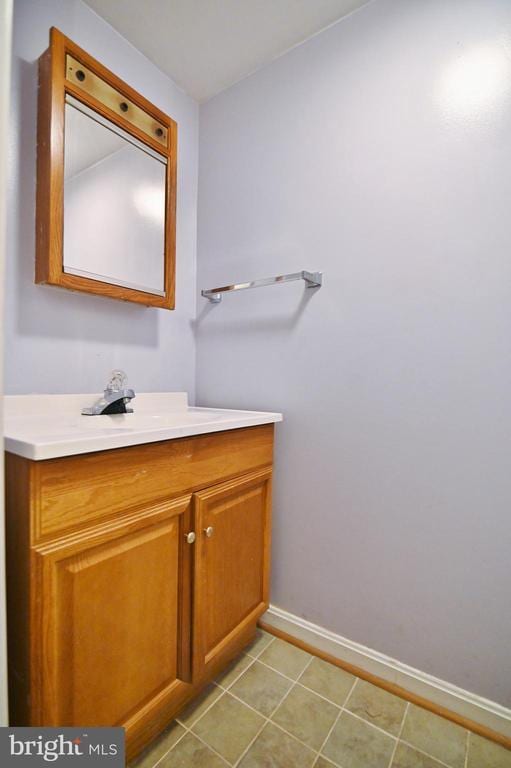 bathroom with baseboards, tile patterned flooring, and vanity