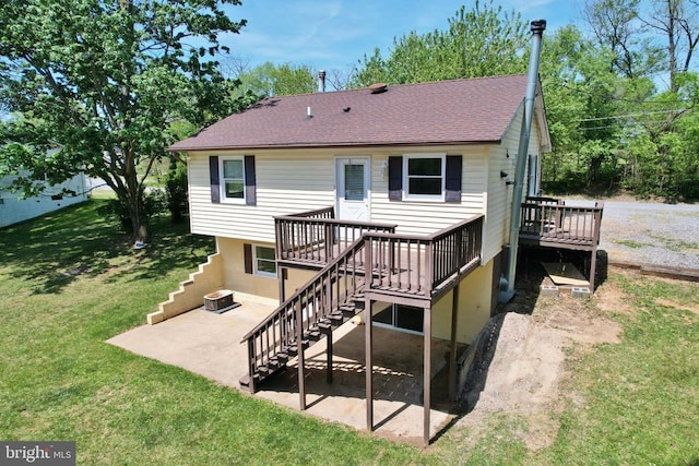rear view of property with roof with shingles, a lawn, a deck, stairway, and a patio