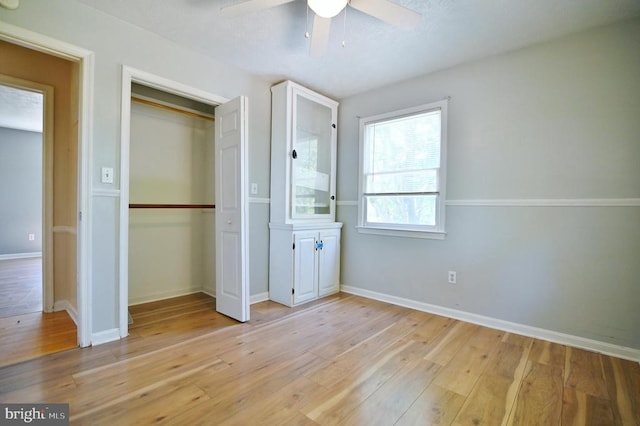 unfurnished bedroom featuring a closet, a ceiling fan, light wood finished floors, and baseboards