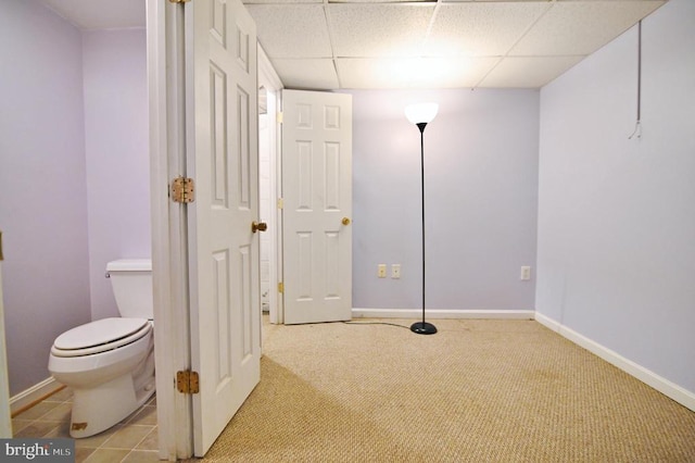 below grade area featuring carpet floors, baseboards, and a paneled ceiling