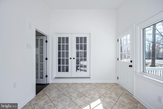 entryway featuring light tile patterned floors, baseboards, and french doors