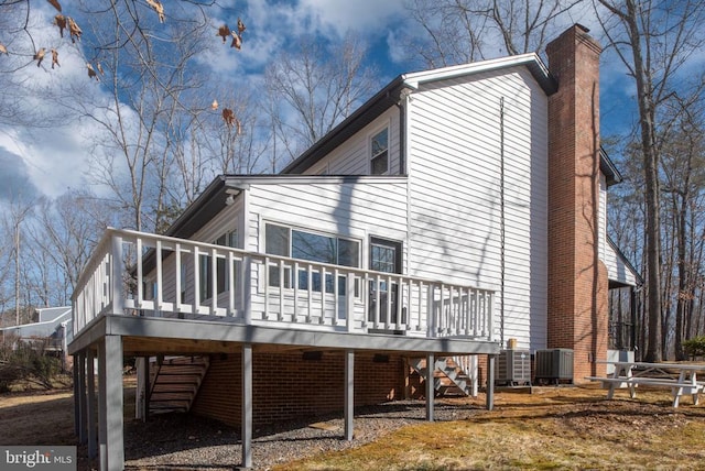 view of side of property with a chimney, stairway, a wooden deck, central air condition unit, and a carport