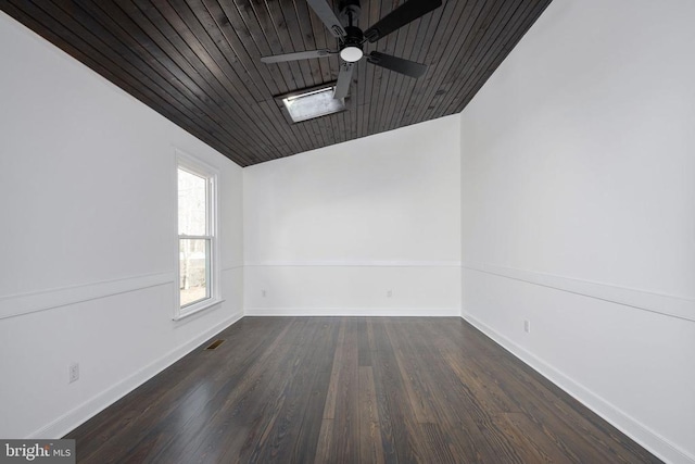 empty room with wooden ceiling, wood finished floors, visible vents, a ceiling fan, and baseboards