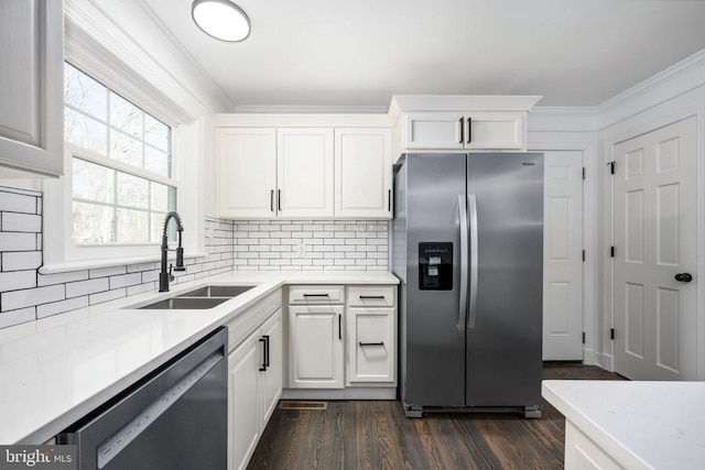 kitchen featuring a sink, light countertops, appliances with stainless steel finishes, backsplash, and crown molding