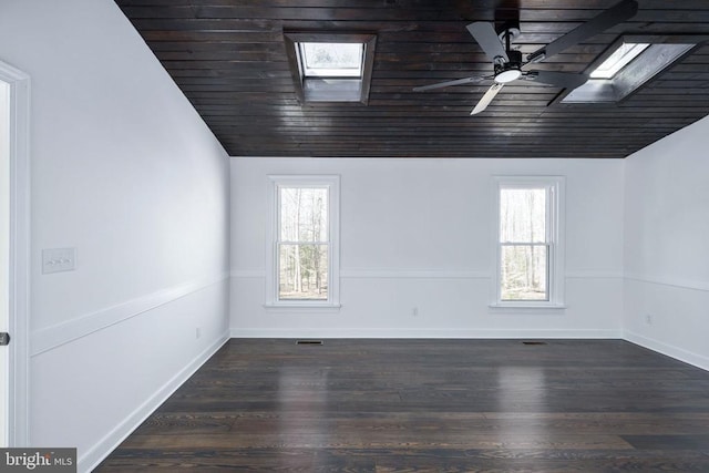 spare room with dark wood-type flooring, plenty of natural light, and lofted ceiling with skylight