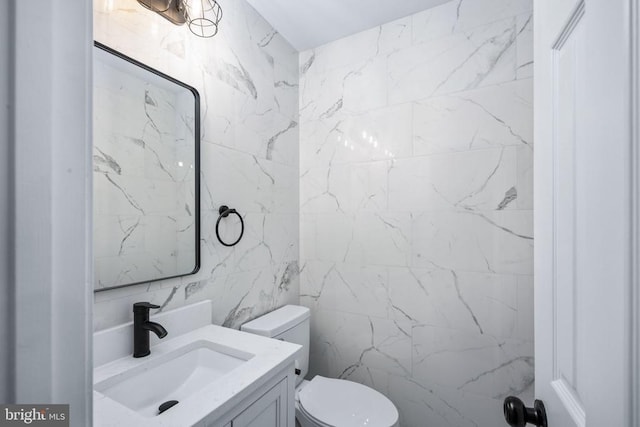 bathroom featuring toilet, tile walls, and vanity