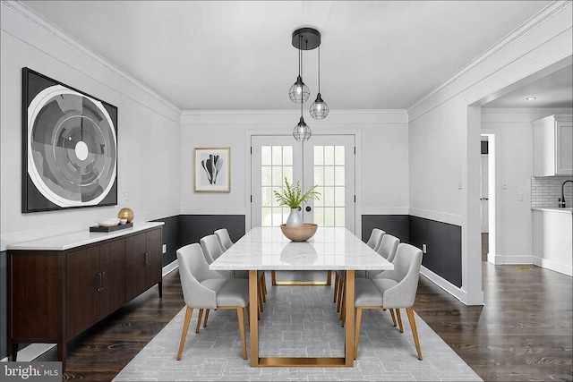 dining room with baseboards, ornamental molding, and dark wood-style flooring