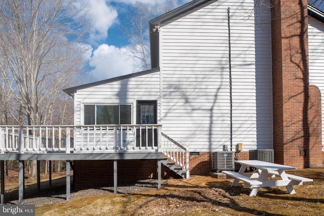 rear view of property with stairway, cooling unit, crawl space, and a deck