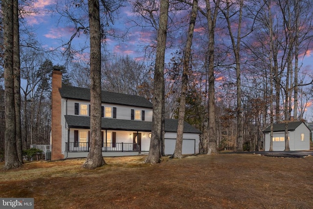 view of front of property featuring a yard, an outbuilding, a porch, and a chimney