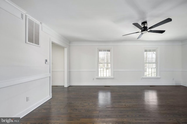 empty room featuring crown molding, baseboards, and wood finished floors