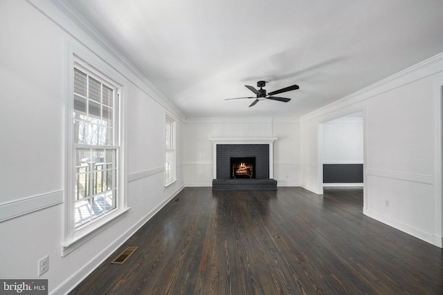 unfurnished living room featuring ornamental molding, dark wood finished floors, visible vents, and a fireplace