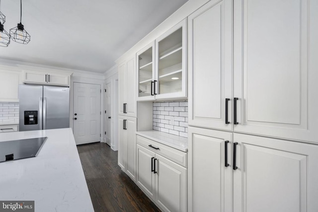 kitchen with tasteful backsplash, stainless steel fridge, glass insert cabinets, and white cabinetry