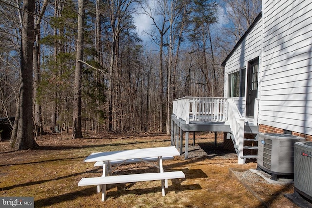 view of yard featuring central AC unit and a wooden deck