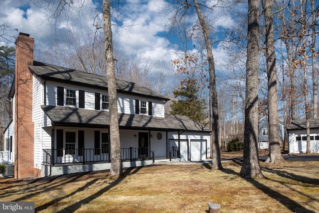 view of front of house with an attached garage, cooling unit, covered porch, a front lawn, and a chimney