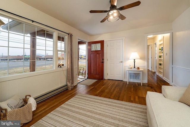 foyer entrance featuring a baseboard heating unit and dark wood-type flooring