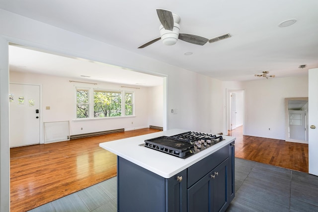 kitchen with visible vents, open floor plan, light countertops, a baseboard radiator, and stainless steel gas cooktop