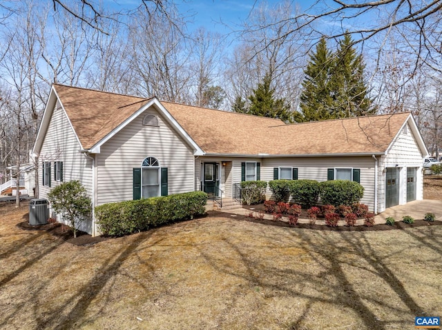 single story home featuring central air condition unit, an attached garage, driveway, and a shingled roof